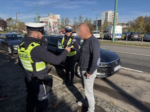 Kolorowe zdjęcie umundurowanych funkcjonariuszy policji oraz ITD przeprowadzających kontrolę pojazdu TAXI.