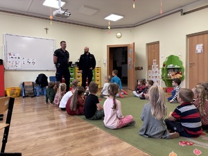 kolorowe zdjęcie umundurowanego policjanta wraz z dziećmi