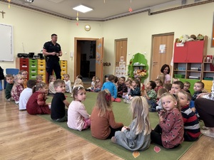 kolorowe zdjęcie umundurowanego policjanta wraz z dziećmi