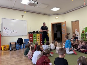 kolorowe zdjęcie umundurowanego policjanta wraz z dziećmi