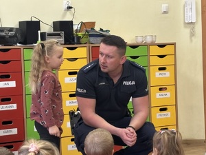 kolorowe zdjęcie umundurowanego policjanta wraz z dziećmi