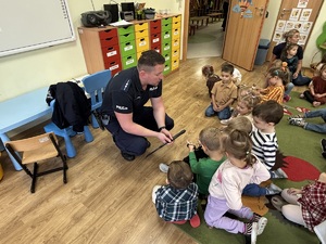 kolorowe zdjęcie umundurowanego policjanta wraz z dziećmi