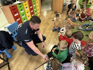 kolorowe zdjęcie umundurowanego policjanta wraz z dziećmi