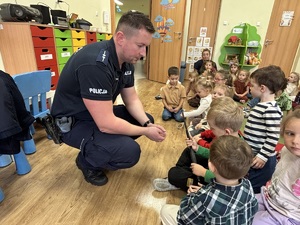 kolorowe zdjęcie umundurowanego policjanta wraz z dziećmi