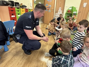 kolorowe zdjęcie umundurowanego policjanta wraz z dziećmi