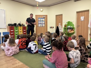 kolorowe zdjęcie umundurowanego policjanta wraz z dziećmi