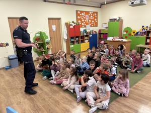 kolorowe zdjęcie umundurowanego policjanta wraz z dziećmi