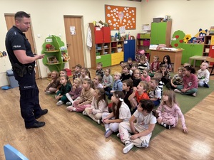 kolorowe zdjęcie umundurowanego policjanta wraz z dziećmi