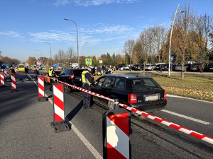 Kolorowe zdjęcie policjantów ruchu drogowego przeprowadzający badanie stanu trzeźwości kierujących samochodami.