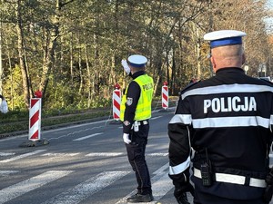kolorowe zdjęcie policjanta kierującego ruchem na przejściu dla pieszych.