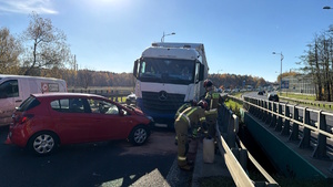 Kolorowe zdjęcie przedstawiające dwa pojazdy uczestniczące w zdarzeniu drogowym, samochód ciężarowy oraz samochód osobowy.