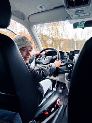 kolorowe zdjęcie chłopca siedzącego na miejscu kierowcy w radiowozie.