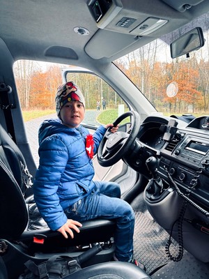 kolorowe zdjęcie chłopca siedzącego na miejscu kierowcy w radiowozie.