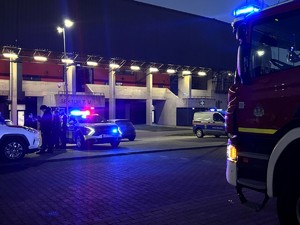 Kolorowe zdjęcie radiowozu policji, wozu strażackiego oraz radiowozu straży miejskiej na tle stadionu miejskiego  w Tychach.