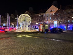 Kolorowe zdjęcie wozu strażackiego na tle fontanny świetlnej