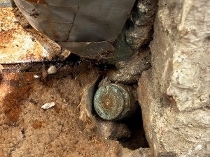 kolorowe zdjęcie niewypału w posadzce piwnicy.