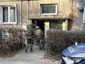 Kolorowe zdjęcie na którym widać saperów wchodzących do budynku.