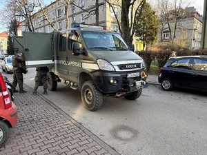 Kolorowe zdjęcie saperów stojących przy pojeździe wojskowym.