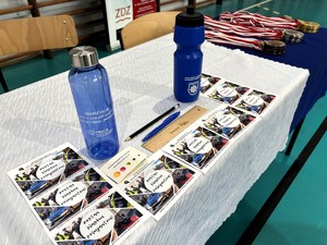 kolorowe zdjęcie gadżetów promocyjnych z logo policja leżące na stole.