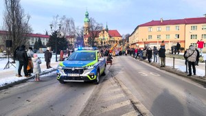 Kolorowe zdjęcie oznakowanego radiowozu na ulicy miasta