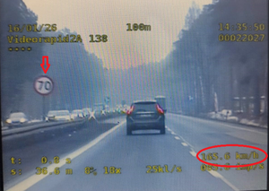 Kolorowe zdjęcie ekranu videorejestratora na którym widoczny jest fragment drogi krajowej numer 1 oraz poruszający się lewym pasem ruchu samochód marki Volvo z nadmierną prędkością.
