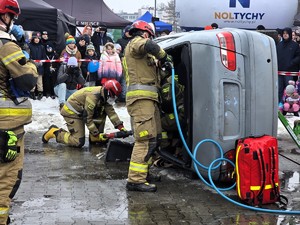 Kolorowe zdjęcie strażaków podczas akcji wycinania osoby z pojazdu.