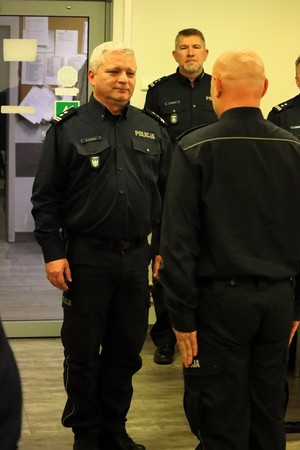 Kolorowe zdjęcie umundurowanych komendantów Policji podczas przyjmowania meldunku o zakończeniu narady rocznej.