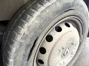 Kolorowe zdjęcie rozciętej opony samochodu typu bus.