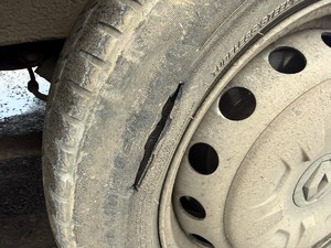 Kolorowe zdjęcie rozciętej opony samochodu typu bus.