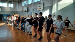 Kolorowe zdjęcie uczniów podczas marszu w miejscu.