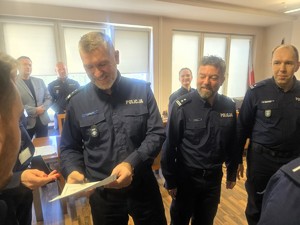 Kolorowe zdjęcie komendanta tyskiej jednostki wręczającego dyplom policjantowi.