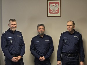 Kolorowe zdjęcie umundurowanych komendantów Komendy Miejskiej Policji w Tychach. W tle widoczne godło Polski.