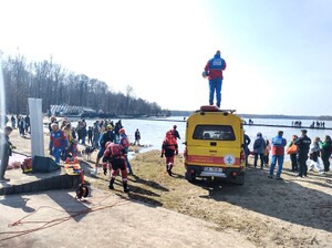 Kolorowe zdjęcie ratowników Wodnego Ochotniczego Pogotowia Ratowniczego stojących przy brzegu jeziora.