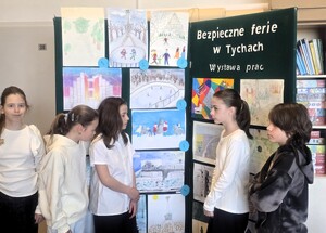 Kolorowe zdjęcie dzieci na tle prac plastycznych wykonanych przez nich.