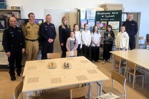 Kolorowe zdjęcie laureatów konkursu stojącymi wraz z gośćmi honorowymi.