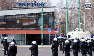 Kolorowe zdjęcie funkcjonariuszy Oddziałów Prewencji Policji na tle dworca PKP.