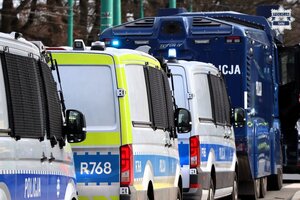 Kolorowe zdjęcie stojących w kolumnie oznakowanych pojazdów Policji.