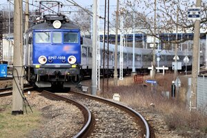 Kolorowe zdjęcie pociągu wjeżdżającego na peron dworca PKP.