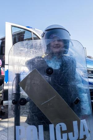 Dziecko trzymające tarcze policyjną w ręku.