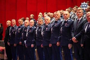 Umundurowani policjanci kadry kierowniczej stojący na widowni.