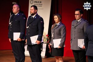 Umundurowani policjanci stojący na scenie po otrzymaniu aktów mianowania.