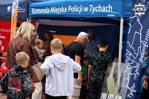 Osoby gromadzące się przy stoisku promocyjnym Policji.