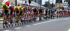Peleton kolarzy jadący jezdnią.