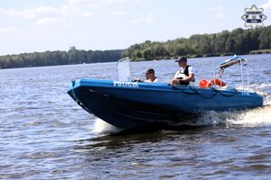 Łódź motorowa Policji manewrująca na jeziorze.